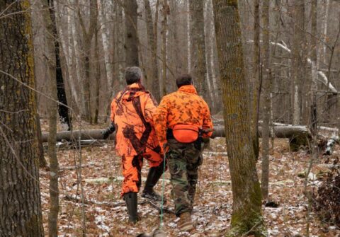 2 men walking in the forest deer hunting